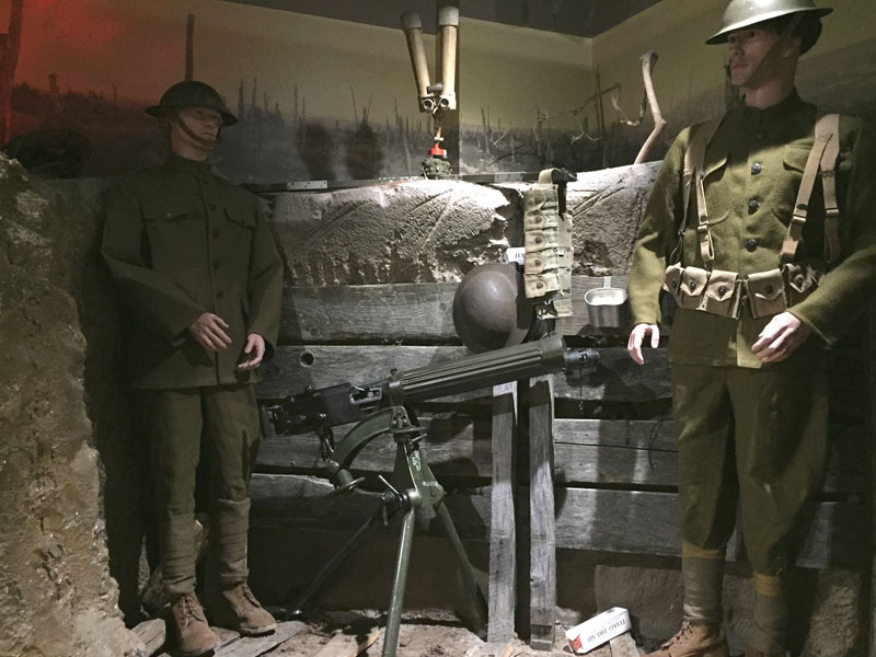 Museum exhibit with two Soldiers standing next to heavy artillery.